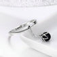 Sterling silver open ring with black pearl charm and chain detail, side view