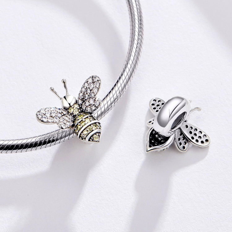 Sterling silver bee charm bead with pavé wings beside a bracelet chain