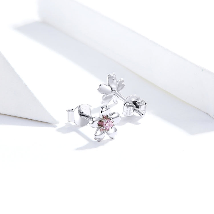 Sterling silver flower stud earring with pink round zircon center, angled side view
