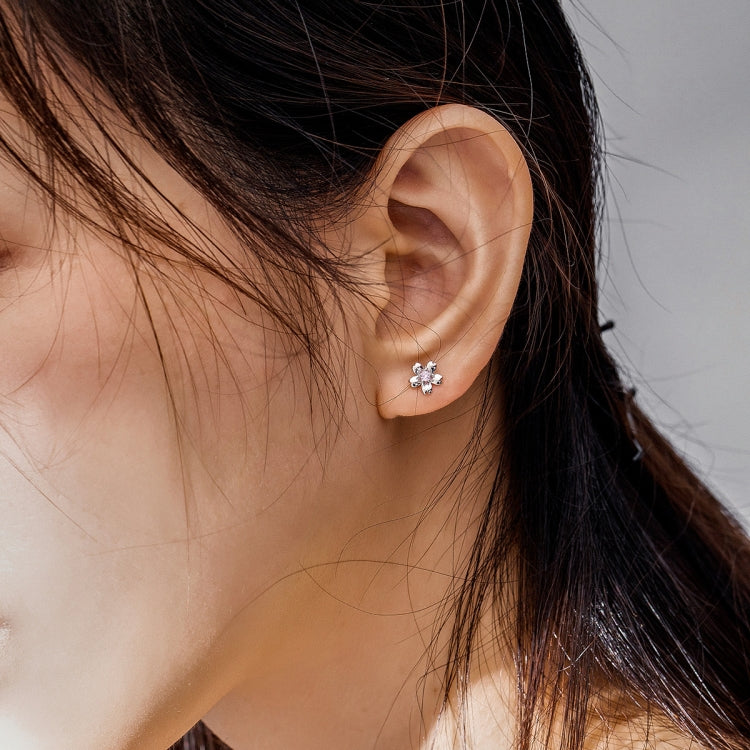 Sterling silver flower stud earrings with pink zircon center on ear