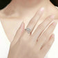 Dainty silver dandelion ring on hand with yellow center and clear CZ stones