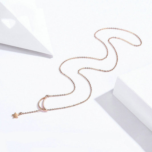 Rose-gold plated moon-and-star pendant necklace laid out on a surface