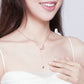 Rose-gold plated moon-and-star pendant necklace worn by a person, close-up