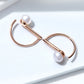Rose gold cuff-style hoop earrings with white shell pearl bead detail