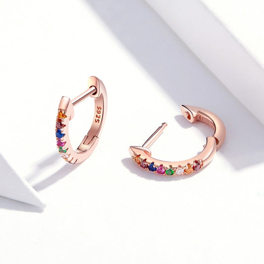 Rose gold hoop earrings with rainbow zircon stones, angled view