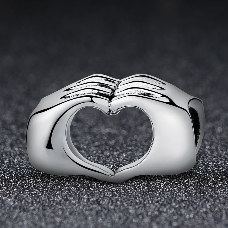 S925 sterling silver heart bead with raised holding-hands motif and heart-shaped cutout