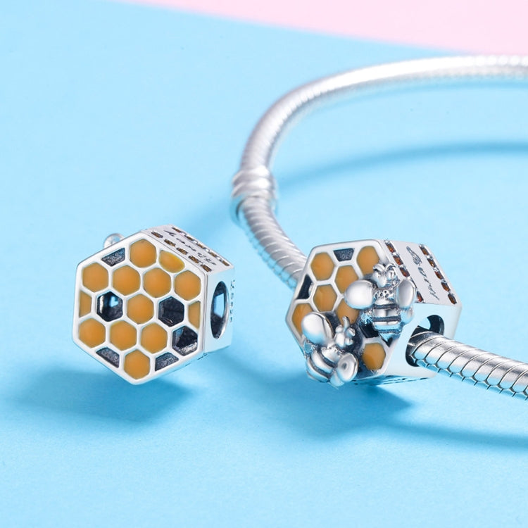 Pair of sterling silver bee hive charm beads with yellow honeycomb enamel on bracelet