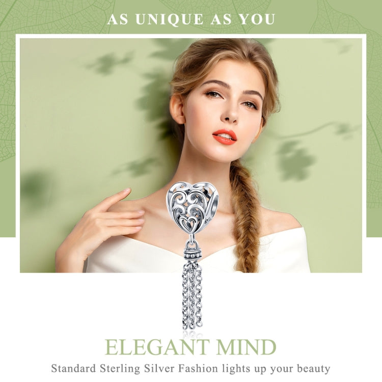 Heart-shaped silver charm bead with heart cutout and dangling chain tassel