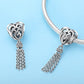 Heart-shaped silver bead charm with chain tassel on a silver bracelet link strand