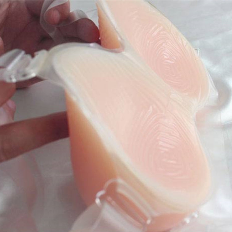 Translucent silicone breast insert with clear strap, close-up