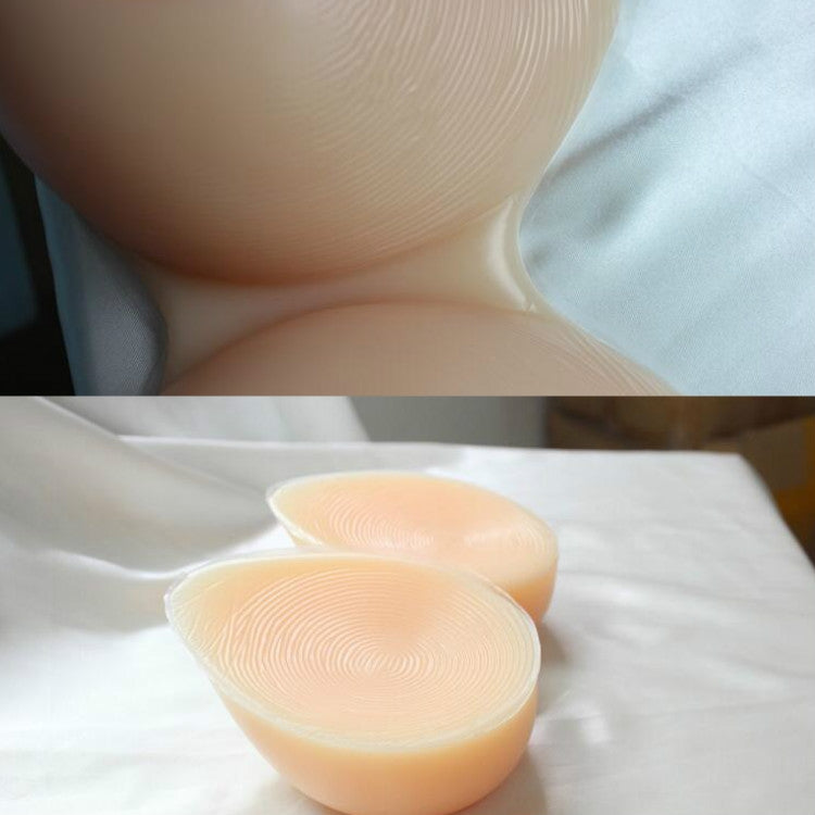 Pair of translucent silicone breast inserts on cloth, rounded cup shape