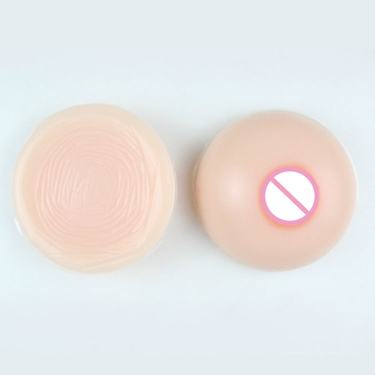 Round silicone breast implants pair, beige silicone with pink areola detail