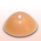 Smooth tan triangular silicone breast insert with concave underside