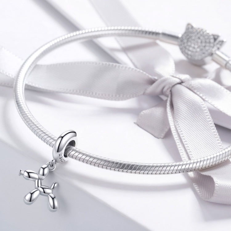 Balloon dog charm bead attached to a silver bracelet with ribbon tie