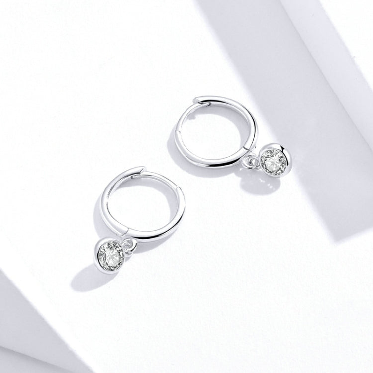Silver hoop earrings with clear zircon charm, side view