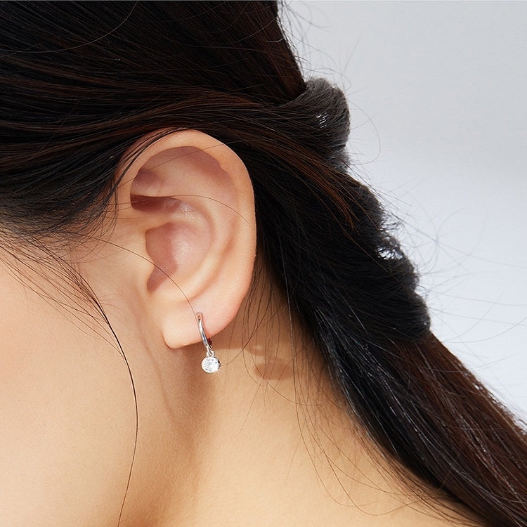 Silver hoop zircon earrings worn, clear round stone dangles
