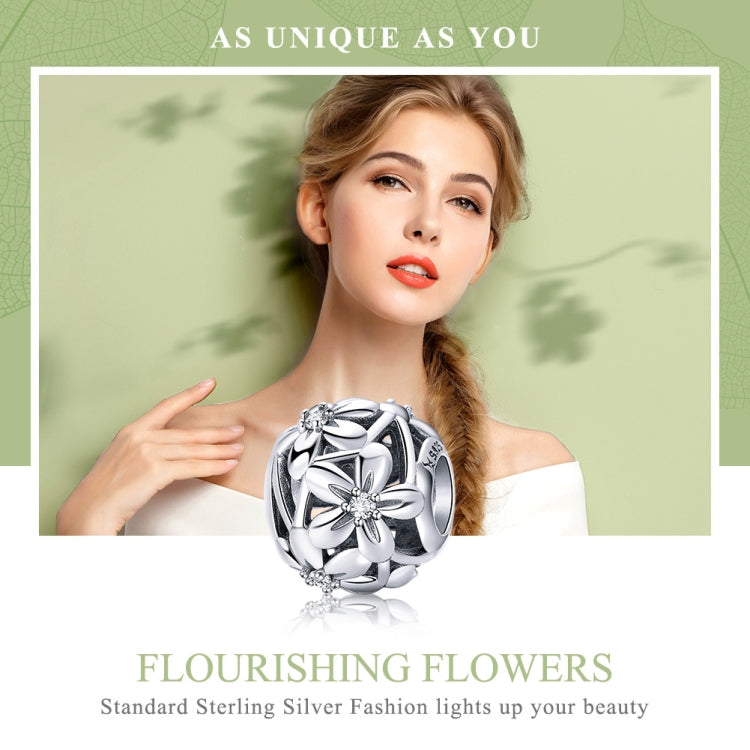 Sterling silver flower charm bead with dripping-oil motif, shown on a bracelet