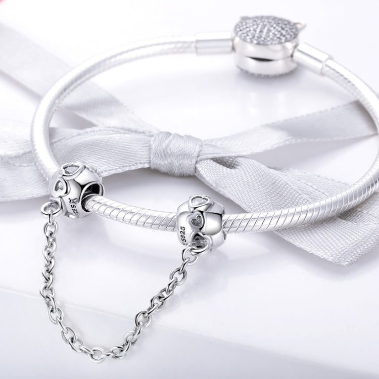 Sterling silver safety chain attached to a charm bracelet with two bead clips