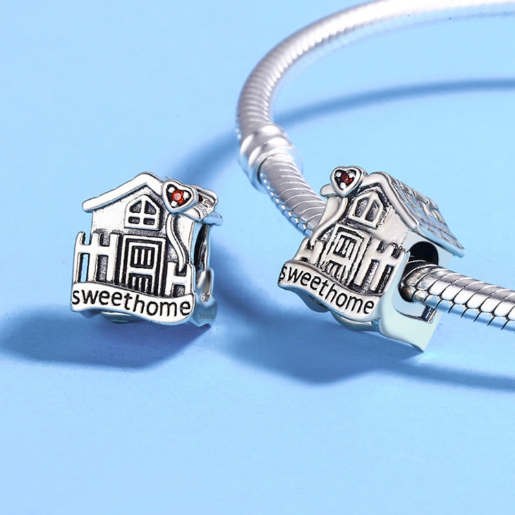 Silver charm bracelet with house charm bead featuring red heart