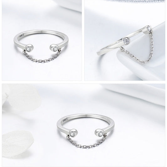 Silver open ring with two round CZ stones and a linked chain detail on the band