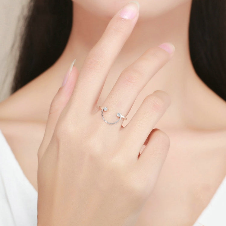 Silver open ring with small round CZ stone and linked chain detail on a hand
