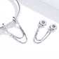 Close-up of silver chain safety bracelet with oval caps, link connectors, and CZ stones