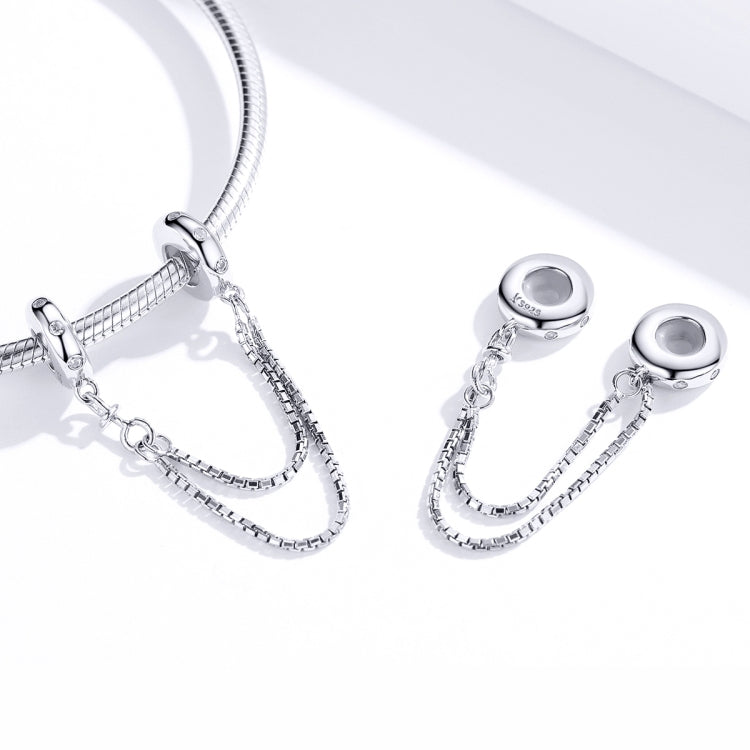 Close-up of silver chain safety bracelet with oval caps, link connectors, and CZ stones