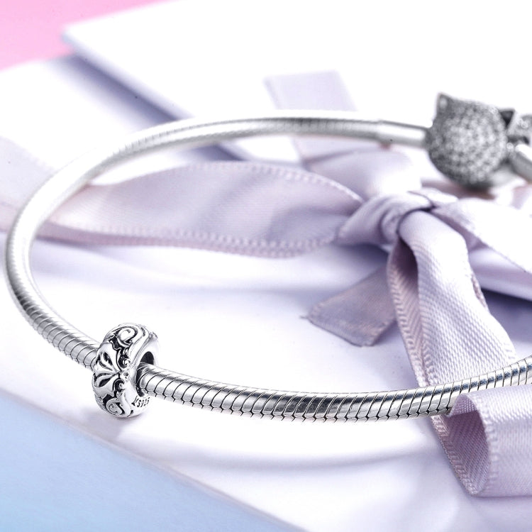 Sterling silver flower-pattern bead charm on a braided bracelet chain with bow