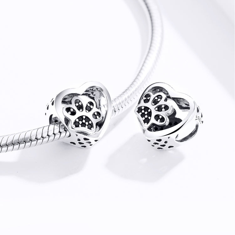Two silver heart paw print bead charms on a snake chain bracelet