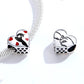 Sterling silver bracelet with two heart-shaped charms in black silhouette and red enamel