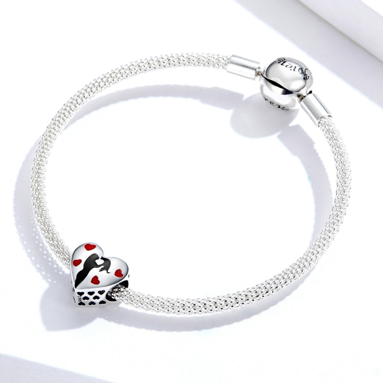 Beaded silver bracelet with heart-shaped charm featuring black silhouette and red enamel hearts