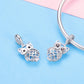 Pair of owl charm pendants in sterling silver with blue enamel wings and rhinestone details