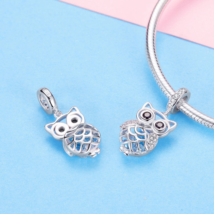 Pair of owl charm pendants in sterling silver with blue enamel wings and rhinestone details