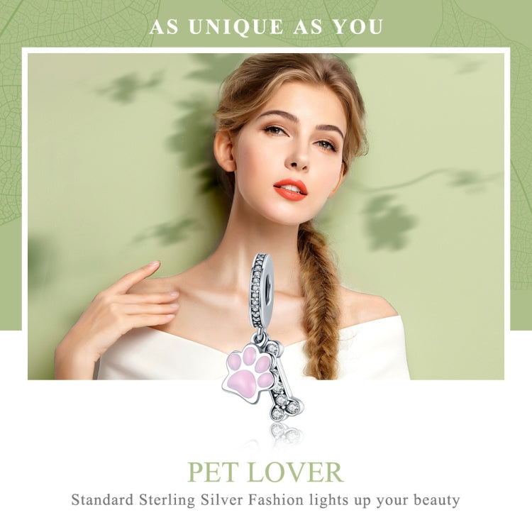 Silver bracelet charm with pink paw-print enamel and dangling CZ bone charm