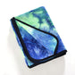 Foldable microfiber non-slip yoga mat towel in blue and green tie-dye with black strap