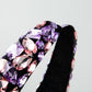 Side view of wide purple rhinestone headband with black velvet interior