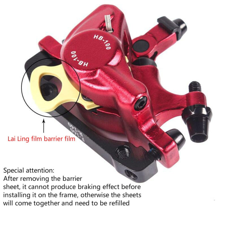 Red hydraulic disc brake caliper close-up showing frame contact and yellow insulator pad