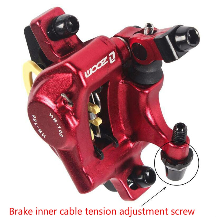 Red hydraulic disc brake caliper close-up with black cable fitting and mounting bolts