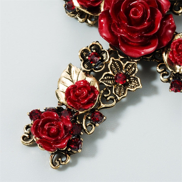 Close-up red rose cross dangle earrings with gold-tone flowers and black rhinestone trims