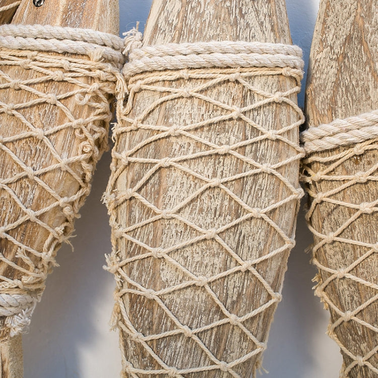 Close-up of net-wrapped wooden fish ornament with woven twine texture