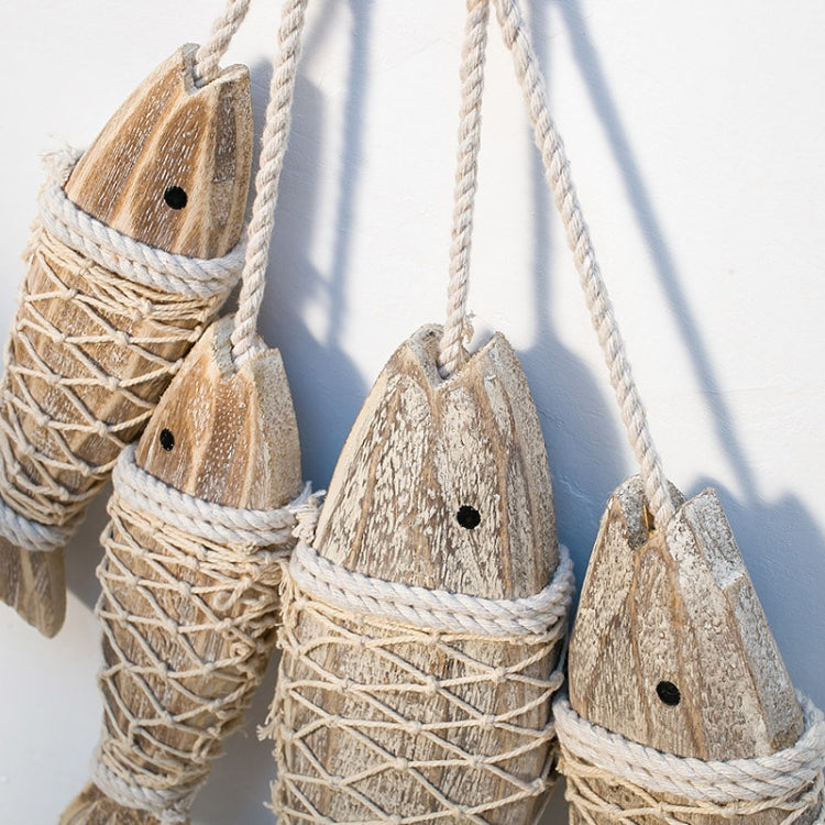 Cluster of hanging wooden fish ornaments with carved heads and twine netting