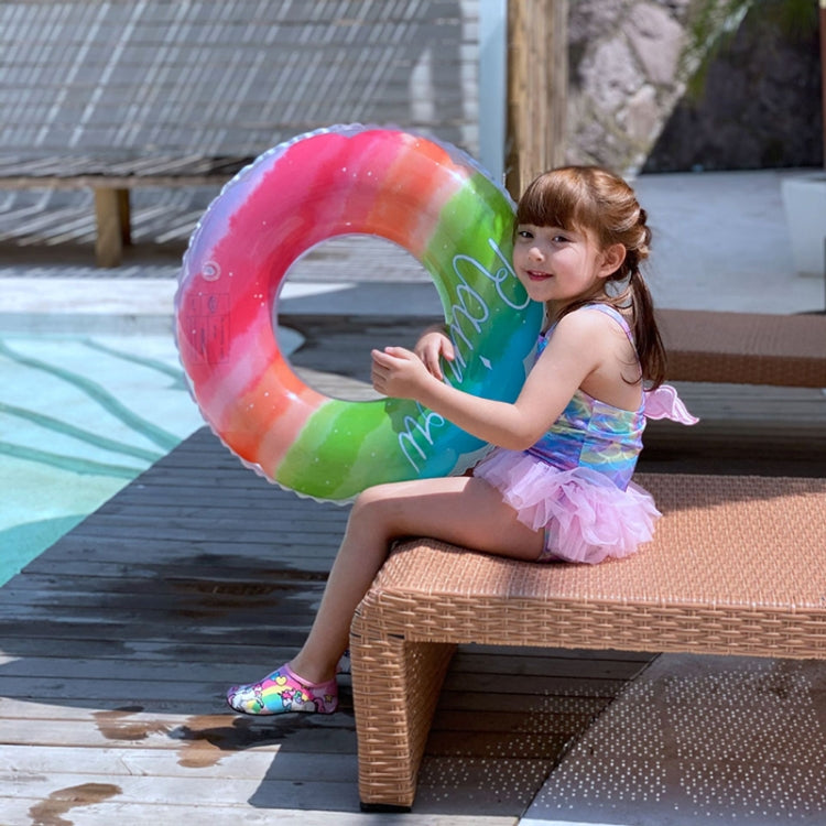 Child holding a rainbow gradient PVC swimming ring near the pool edge