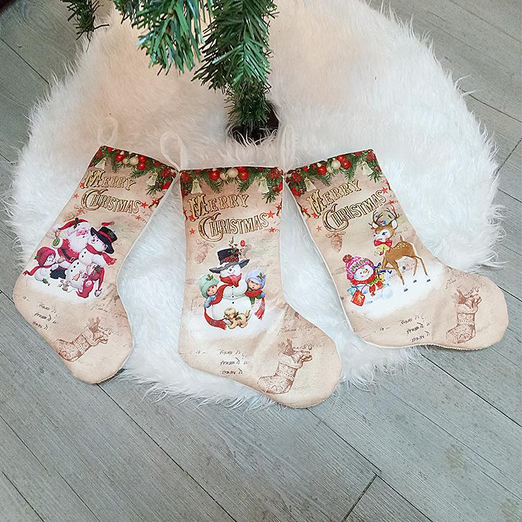 Set of three beige Christmas stockings with Merry Christmas and winter character prints.