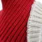 Close-up of red knit wool hat with cream ribbed trim and stitched texture