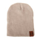 Light beige knit baby beanie with folded cuff and leather patch label on side
