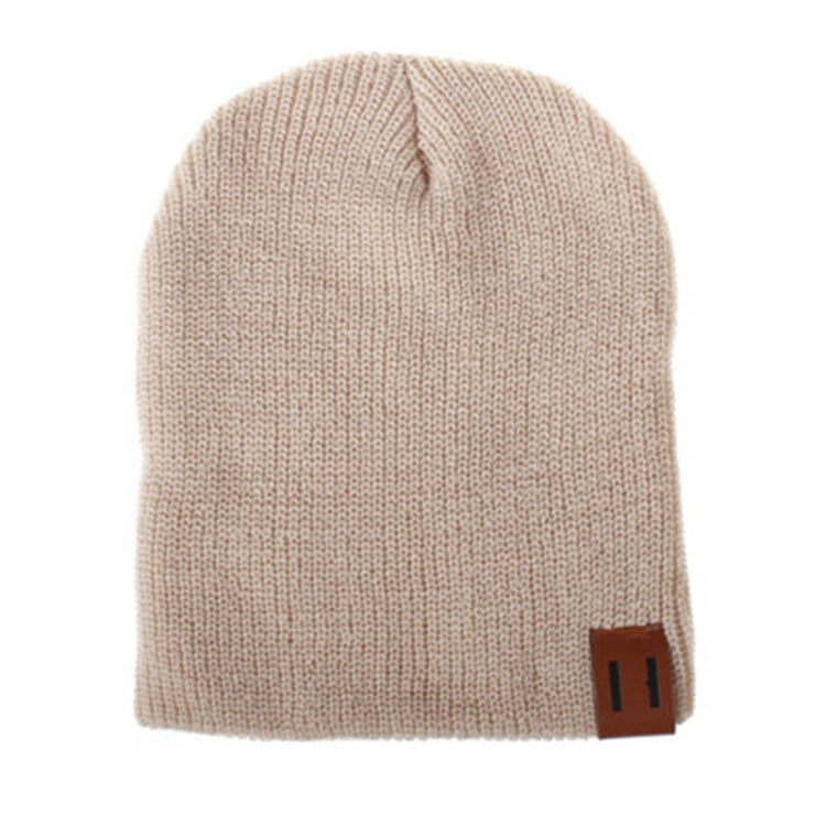 Light beige knit baby beanie with folded cuff and leather patch label on side