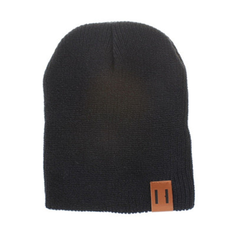 Black knit baby beanie with folded cuff and square leather patch label