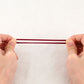 Girls hair rubber bands, burgundy elastic strip held by hands