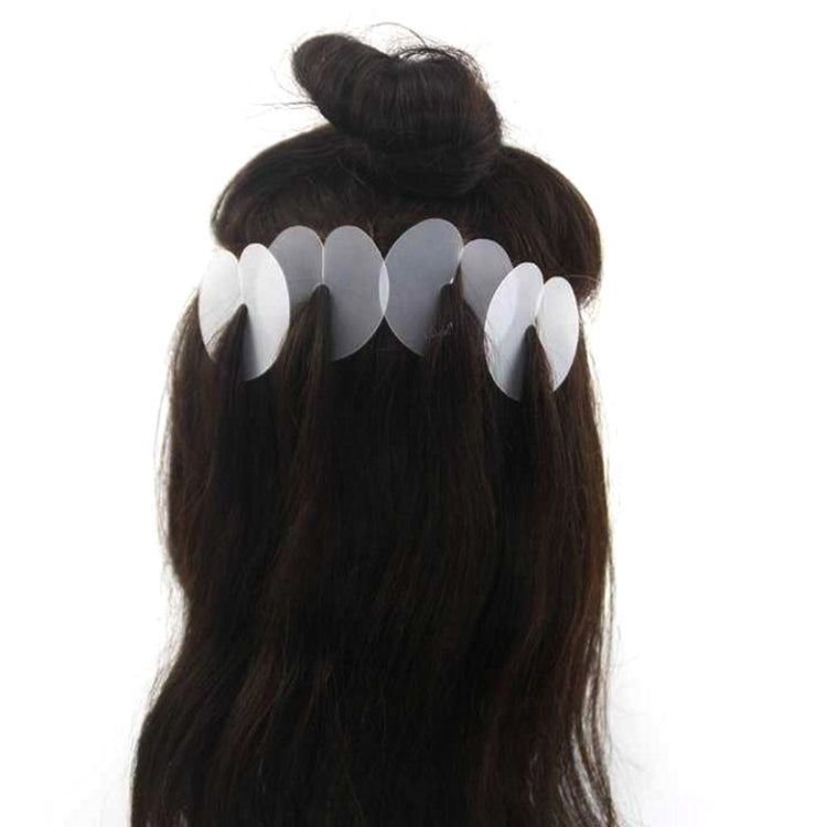 Black wig hair extension with white insulation film tabs clipped along the hair