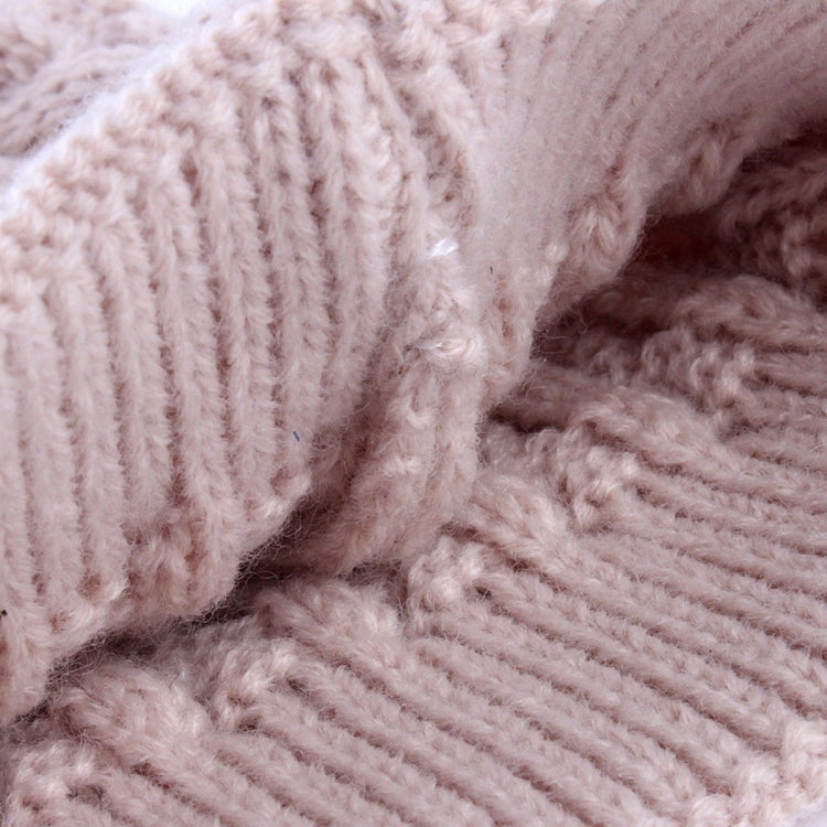 Light pink knit beanie fabric close-up with ribbed texture and soft faux-fur pom pom